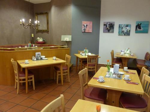 ein Restaurant mit Holztischen und Stühlen und einer Theke in der Unterkunft Hotel Nibelungen Hof in Xanten