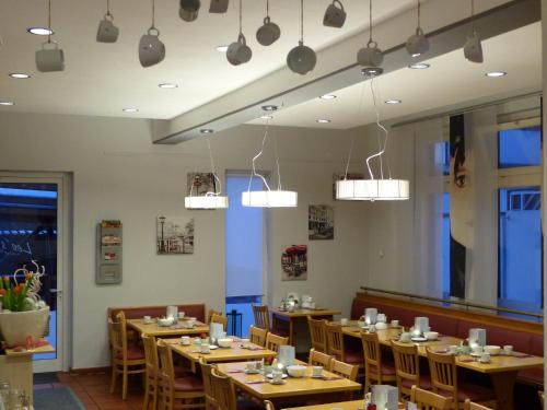 ein Restaurant mit Holztischen und Stühlen und Lichtern in der Unterkunft Hotel Nibelungen Hof in Xanten