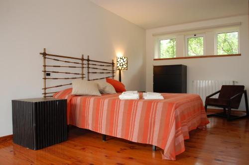 1 dormitorio con 1 cama con sábanas de color naranja y blanco en Casa Penedo da Saudade, en Afife