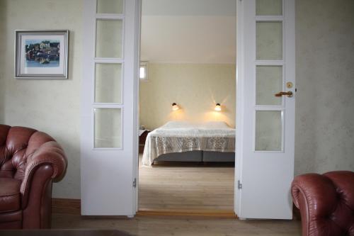 a bedroom with a bed in a room with two open doors at Brudhäll Hotel & Restaurant in Kökar