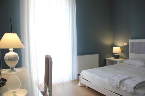 a bedroom with a white bed and a large window at Residenza del Maestro in Matera