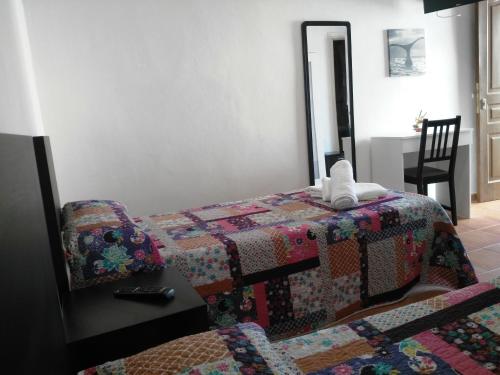 Un dormitorio con un edredón en una cama y una mesa en Parrilla Venta el Andaluz, en Conil de la Frontera