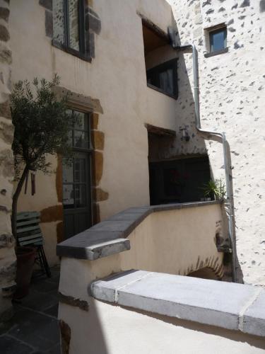 a building with a staircase leading up to a door at Les quatre provinces d'Irlande in Saint-Amant-Tallende