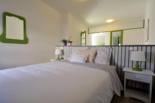 a bedroom with a large white bed and a mirror at Casa Villalba in San Bartolomé