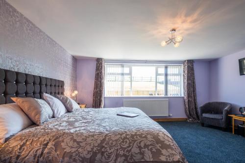 a bedroom with a large bed and a window at Lazy Days in Whitby