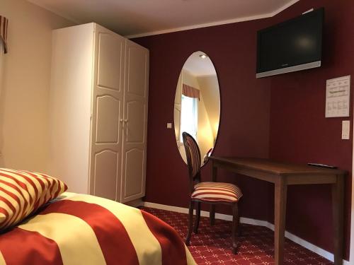 a bedroom with a bed and a desk and a mirror at Bramslevgaard in Hobro