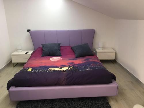 アヴォラにあるSTANZA PRIVATA 2 POSTI LETTO CON BAGNOのテーブル2台付きの部屋の紫色のベッド1台