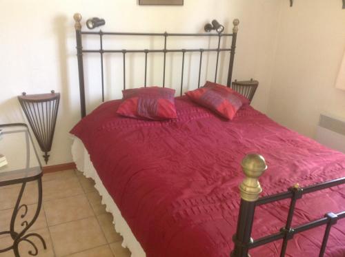 - un lit avec une couette rouge et 2 oreillers dans l'établissement Village Le Chat, à Écuras