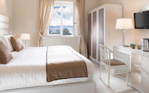 a bedroom with a bed and a desk and a window at Europa Grand Hotel in Lerici