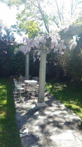 a table and chairs under a pergola with flowers at B&B La Villa Mediterranea in Passirano