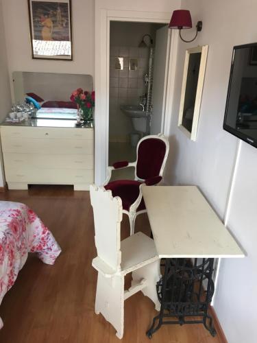 a room with a table and two chairs and a bed at Affittacamere Arco Polinori in Foligno