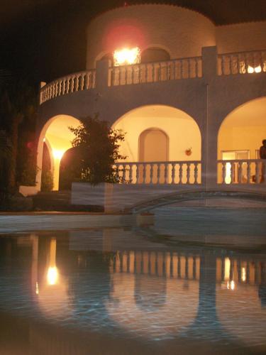 a building with a reflection in the water at night at Studio - Casa Martin in San Sebastián de la Gomera