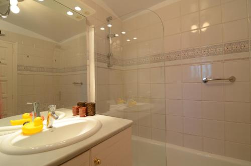 uma casa de banho branca com um lavatório e um chuveiro em Plaça Dels Pous 3 em Pals