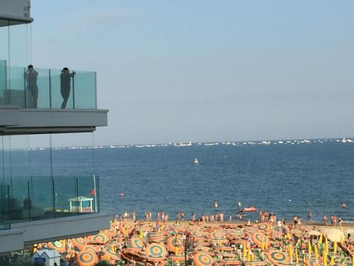 un grupo de personas en una playa con el océano en Heron apartments, en Lido di Jesolo