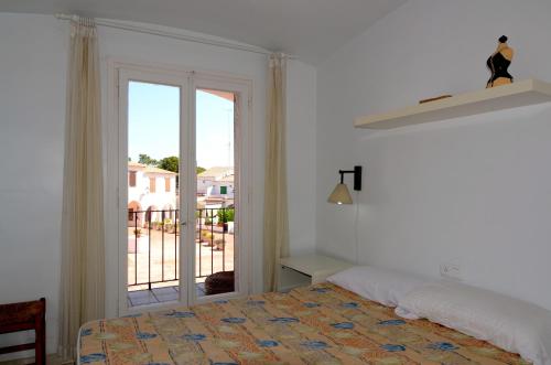 a bedroom with a bed and a sliding glass door at Plaça Dels Pous 3 in Pals