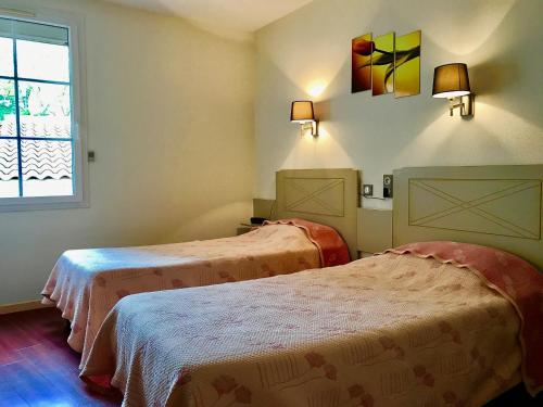 pokój z dwoma łóżkami i oknem w obiekcie Logis Hotels - Hôtel et Restaurant de la Montagne Noire w mieście Dourgne