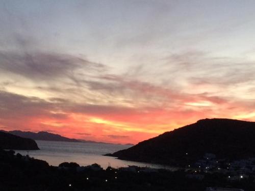 a sunset over a body of water with mountains at Villa Costa Studios in Vathi, Sifnos