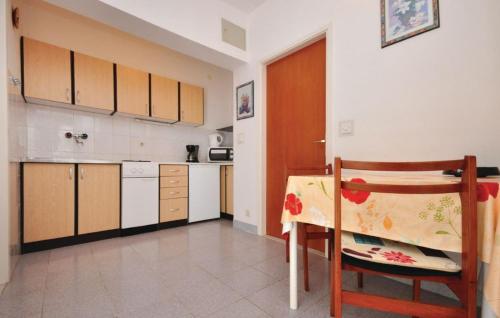 a kitchen with a table and a chair in a room at Apartments Coko in Omiš