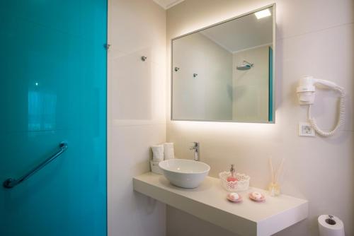 a bathroom with a sink and a mirror at Hermes Beach Front in Stalos