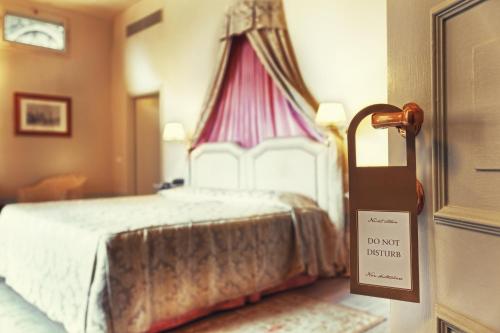 a bedroom with a bed with a sign on the door at Palazzo Niccolini al Duomo Residenza D'Epoca in Florence