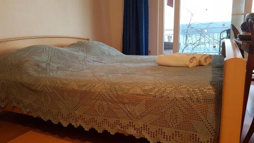 a bed with a blanket and a towel on it at Apartments Coko in Omiš