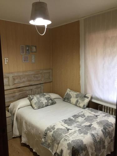 een slaapkamer met een bed met 2 kussens erop bij Casa Rural Fuentesil in Robles de Laciana