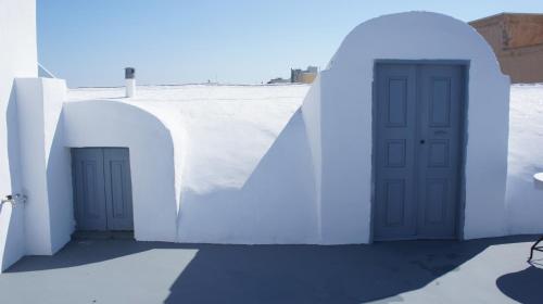 a white and blue building with a white door at Marcos Rooms in Oia