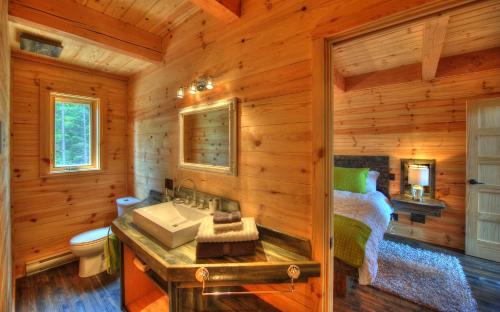 a bathroom with a sink in a log cabin at Le Val d'Isère - Les Chalets Spa Canada in La Malbaie