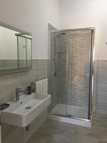 a bathroom with a sink and a glass shower at Le Anfore Hotel - Lampedusa in Lampedusa
