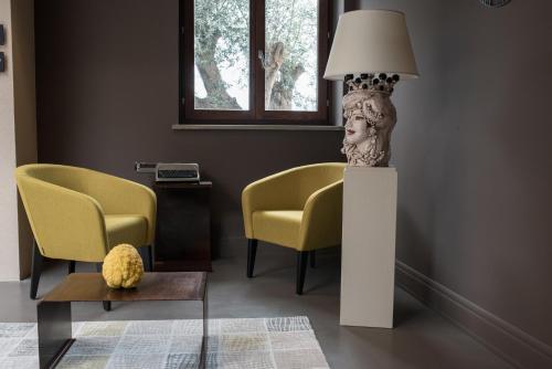 a living room with two chairs and a table with a lamp at Best Western Plus Hotel Terre di Eolo in Patti