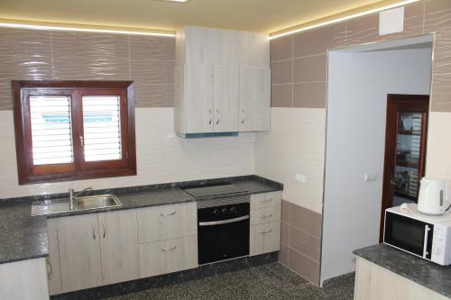 a kitchen with a sink and a stove top oven at Can Mossènyer in San Antonio