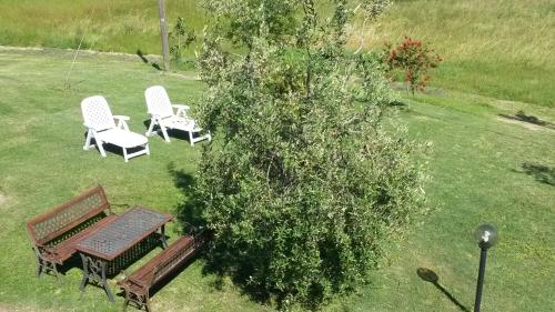 two chairs and a picnic table and a bush at Casa il Ponte in Chianni