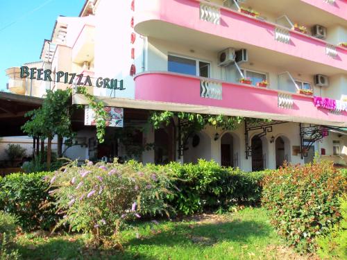 a large pink building with a sign on it at Arkadia Guest House in Primorsko