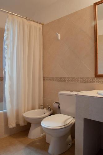 a bathroom with a white toilet and a sink at Leyenda Posada in Capilla del Monte