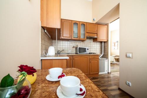 a kitchen with a table with two cups on it at Queens Apartments in Lviv