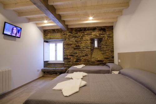 a room with a bed with towels on it at Pensión Domus Gallery in Arzúa