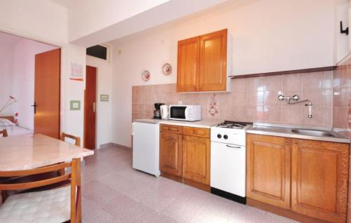 a kitchen with wooden cabinets and a white appliances at Apartments Coko in Omiš