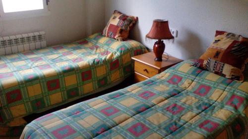 a bedroom with two beds and a lamp on a night stand at Casa Toño in Medinaceli