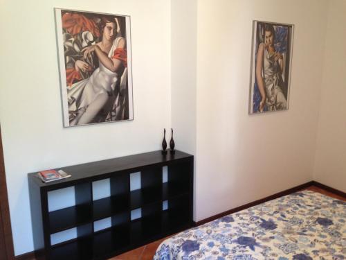 a bedroom with two paintings on the wall and a bed at Vecchia Filanda Musso 1A in Musso