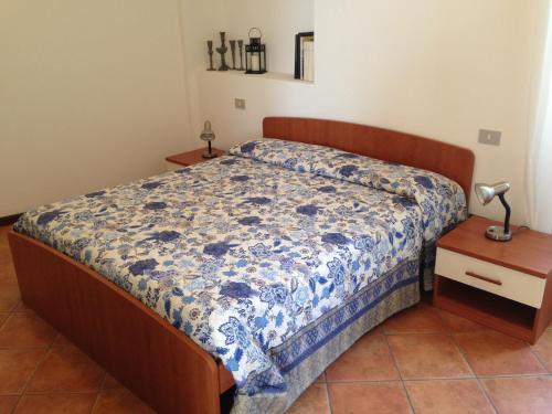 a bedroom with a bed with a blue and white comforter at Vecchia Filanda Musso 1A in Musso