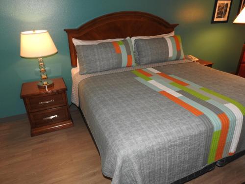 a bedroom with a bed and a nightstand with a lamp at Edelweiss Inn in Eureka Springs