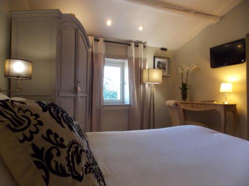 Ένα ή περισσότερα κρεβάτια σε δωμάτιο στο Hostellerie Le Roy Soleil