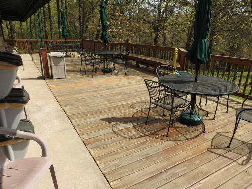 a deck with tables and chairs on a wooden deck at Edelweiss Inn in Eureka Springs