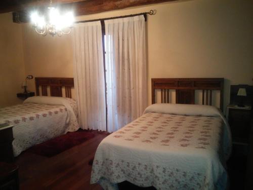 a bedroom with two beds and a chandelier at Casa Colason in El Otero