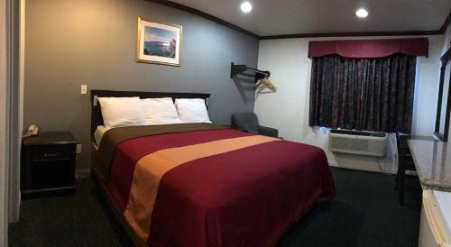 a hotel room with a bed and a window at Starlight Inn Canoga Park in Canoga Park