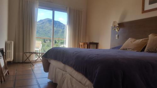 um quarto com uma cama e vista para uma montanha em Montecassino em Capilla del Monte