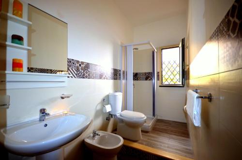 a white bathroom with a sink and a toilet at Naxos Sea Holiday Apartments in Giardini Naxos