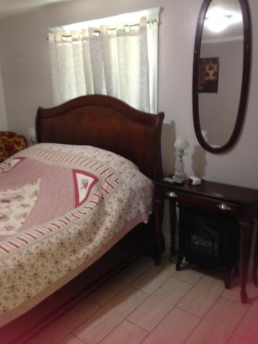 a bedroom with a bed with a mirror and a table at Foster Lake Inn in Sweet Home
