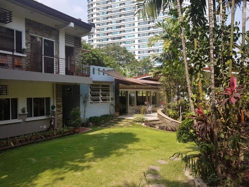 a yard in front of a house with a tall building at New Manila Suites in Manila