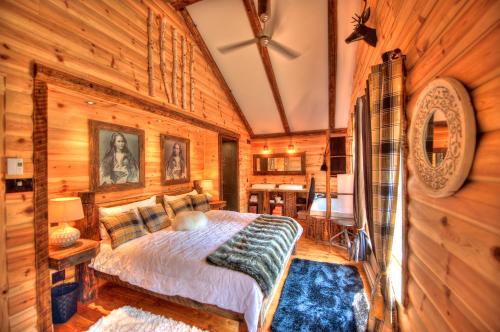 ein Schlafzimmer mit einem Bett in einem Zimmer mit Holzwänden in der Unterkunft Le St Bernard - Les Chalets Spa Canada in La Malbaie